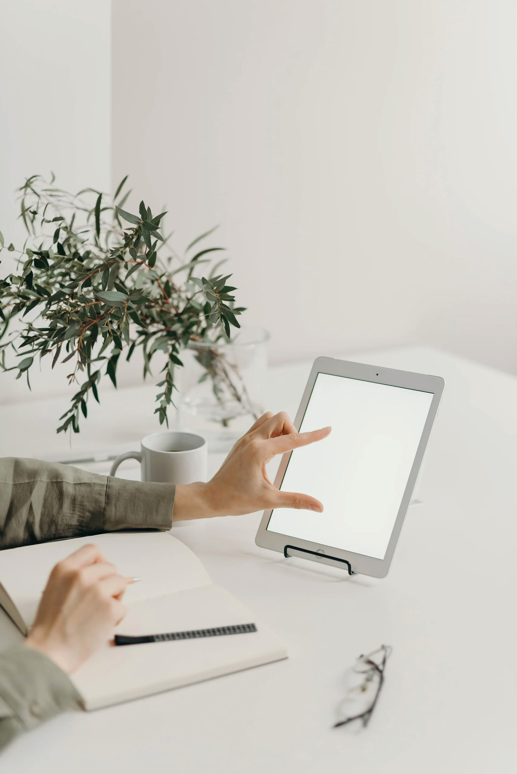 A consultation note-taking setup with a tablet and notebook